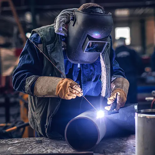 soudeur porte des gants et pratique la manutention fine en atelier